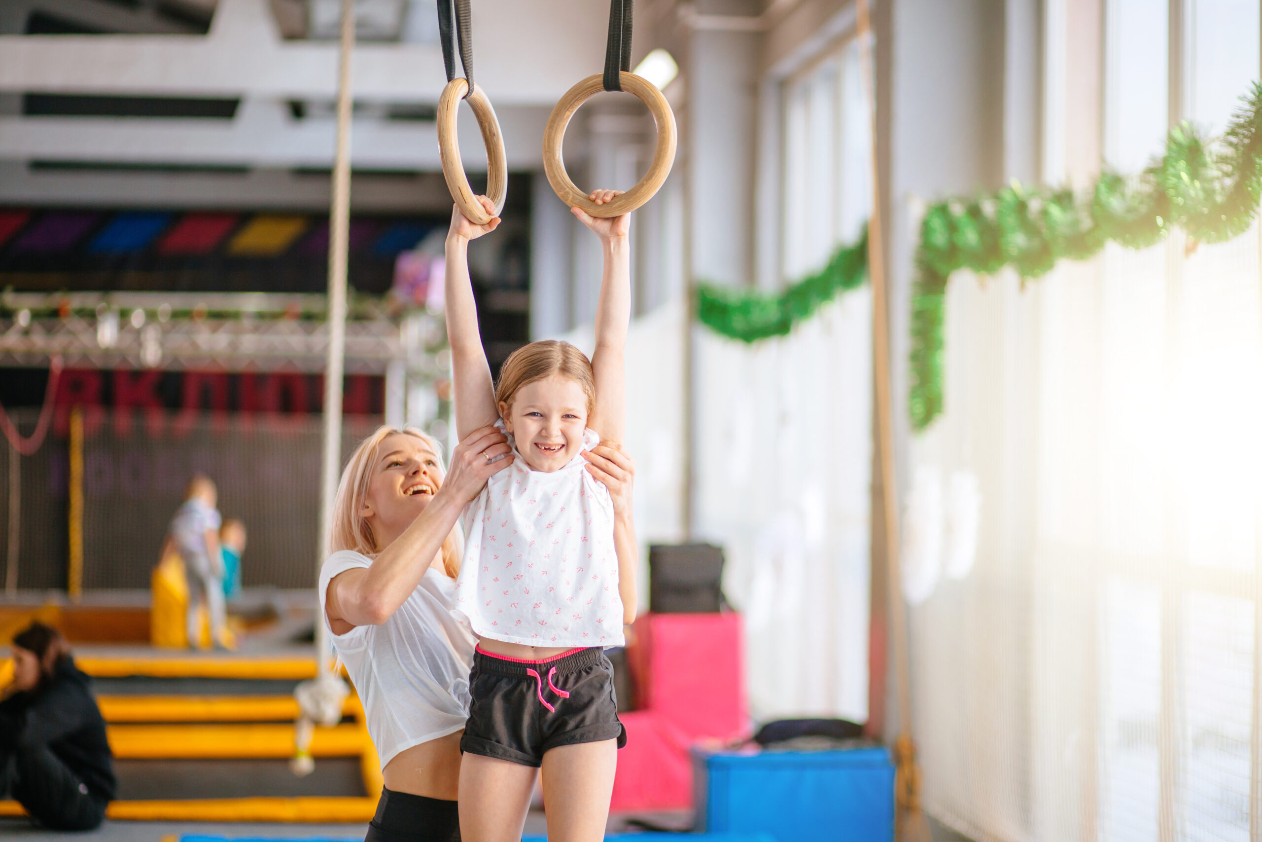 coach and little girl on rings