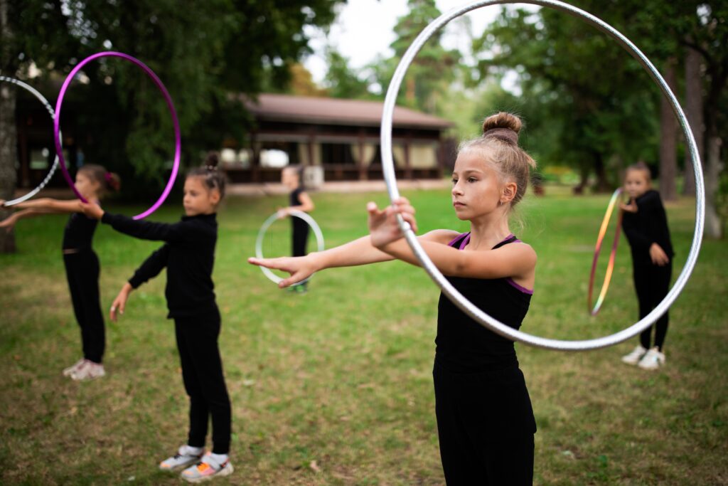 Group of Girls Trainees Doing Exercise with Hoop on Rhythmic