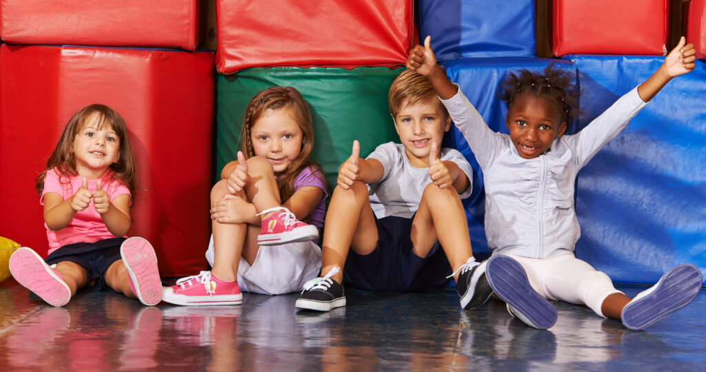 Happy Group of Kids in Preschool Gym Holding Their Thumbs